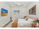 This staged bedroom has a ceiling fan, wall-mounted TV, and plantation shutters at 10147 W Camino De Oro --, Peoria, AZ 85383