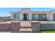 Inviting front exterior with decorative brick walkway, covered porch, and well-maintained landscaping at 10147 W Camino De Oro --, Peoria, AZ 85383