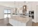 Elegant kitchen featuring white cabinets, marble countertops, stainless steel appliances, and pendant lighting at 10147 W Camino De Oro --, Peoria, AZ 85383