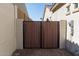 Backyard with a brown wooden gate and beige stucco walls at 10249 W Redbird Rd, Peoria, AZ 85383