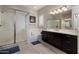 Bright bathroom featuring a glass shower, soaking tub, and dual sink vanity at 10249 W Redbird Rd, Peoria, AZ 85383