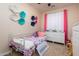 Cozy bedroom with a white metal frame bed, white dresser, and colorful wall decor at 10249 W Redbird Rd, Peoria, AZ 85383