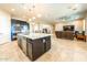 Open-concept kitchen with an island that offers seating, stainless steel appliances, and views into the living room at 10249 W Redbird Rd, Peoria, AZ 85383