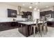 Well-equipped kitchen with dark wood cabinets, a stainless steel range hood, and a central island with seating at 10249 W Redbird Rd, Peoria, AZ 85383