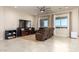 Spacious living room featuring tile flooring, neutral walls, and comfortable leather seating under natural light at 10249 W Redbird Rd, Peoria, AZ 85383