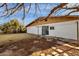 Large backyard showing the white brick facade of the home, and a concrete patio at 104 S Doran --, Mesa, AZ 85204