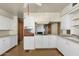 Outdated kitchen featuring white cabinets, laminate countertops, and a view of a fireplace at 104 S Doran --, Mesa, AZ 85204