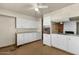 Outdated kitchen featuring white cabinets, laminate countertops, and a ceiling fan at 104 S Doran --, Mesa, AZ 85204