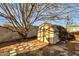 Backyard shed with shingled roof and paver stone walkway, surrounded by mature tree at 104 S Doran --, Mesa, AZ 85204