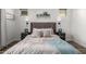 Inviting bedroom with a large upholstered headboard, stylish nightstands and lamps, and modern wall art at 10532 E Palladium Dr, Mesa, AZ 85212