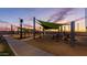 A playground featuring swings, slides, and climbing structures under shaded canopies at 10532 E Palladium Dr, Mesa, AZ 85212