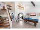 Bright living room with a soaring ceiling, a staircase, and an adjacent dining area with a pool table at 10800 N 101St St, Scottsdale, AZ 85260