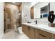 Modern bathroom with a glass shower, wood vanity, and black fixtures at 109 E Hayward Ave, Phoenix, AZ 85020