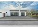 Modern home showcasing a large garage with glass doors and a driveway with grass accents at 109 E Hayward Ave, Phoenix, AZ 85020