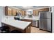 Efficient kitchen featuring wood cabinets, a stainless steel refrigerator, and a breakfast bar at 11010 E Keats Ave, Mesa, AZ 85209