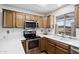 Well-lit kitchen with wooden cabinets, stainless steel appliances, and a window overlooking the outdoors at 11010 E Keats Ave, Mesa, AZ 85209