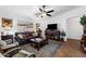 Cozy living room with hardwood floors, a ceiling fan, a leather sofa, and a large window at 11010 E Keats Ave, Mesa, AZ 85209