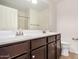 Bathroom with a double sink vanity with a dark wood finish and tiled floors at 11918 W Yearling Ct, Peoria, AZ 85383