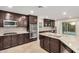 Close up of the kitchen with stainless steel appliances, dark wood cabinets, and granite countertops at 11918 W Yearling Ct, Peoria, AZ 85383