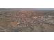 Expansive aerial view of a desert community, showcasing the neighborhood layout and surrounding mountain landscape at dusk at 12008 S 186Th Dr, Goodyear, AZ 85338