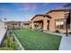 Expansive backyard featuring artificial turf, desert landscaping, and a covered patio at 12008 S 186Th Dr, Goodyear, AZ 85338