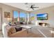 Bright living room featuring neutral tones, large windows, and a ceiling fan for comfortable living at 12008 S 186Th Dr, Goodyear, AZ 85338