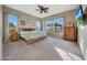 Bright main bedroom featuring multiple windows and a decorative ceiling fan at 12008 S 186Th Dr, Goodyear, AZ 85338