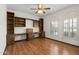 Empty bedroom with hardwood floors, built-in shelving, and shuttered windows at 14401 N 60Th Pl, Scottsdale, AZ 85254