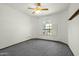 Empty bedroom with carpeted floors, ceiling fan, and a large window with shutters at 14401 N 60Th Pl, Scottsdale, AZ 85254