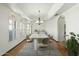 Formal dining room with hardwood floors, arched windows with shutters, tray ceiling, and modern chandelier at 14401 N 60Th Pl, Scottsdale, AZ 85254