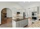 Bright kitchen featuring stainless steel appliances, an island, stone countertops, and white cabinets at 14401 N 60Th Pl, Scottsdale, AZ 85254