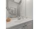 A bathroom single sink, quartz countertop, white cabinet, and decorative mirror at 1549 E Westchester Dr, Chandler, AZ 85249