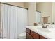 Well-lit bathroom showcasing a shower curtain, sink, and mirror for essential hygiene at 16089 W Harvard St, Goodyear, AZ 85395