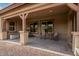 Covered patio features concrete flooring, wood supports, recessed lights, and an outdoor seating area at 16089 W Harvard St, Goodyear, AZ 85395