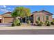 Charming single-story home features a two-car garage, desert landscaping, and mature trees at 16089 W Harvard St, Goodyear, AZ 85395