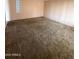 Expansive living room with dated carpet and a window at 1616 E Pecan Rd, Phoenix, AZ 85040