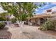 A serene backyard featuring gravel landscaping, a covered patio, and a lush citrus tree at 1632 Leisure World --, Mesa, AZ 85206