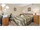 Bedroom with neutral paint, a desk, a wood bed frame with a patterned comforter and plush carpet at 1632 Leisure World --, Mesa, AZ 85206