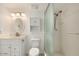 Clean bathroom featuring a white vanity, oval mirror, and a modern shower with glass doors at 16402 N 31St St # 107, Phoenix, AZ 85032