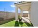 A covered patio extends to a grassy area, all enclosed by a block wall at 17487 W Daley Ln, Surprise, AZ 85387