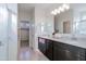 Bathroom showcasing double sinks, granite countertops, modern fixtures, and tile flooring at 17487 W Daley Ln, Surprise, AZ 85387