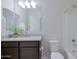 Well-lit bathroom with vanity, granite countertop, large mirror, and a shower/tub combo at 17487 W Daley Ln, Surprise, AZ 85387