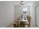 An open dining space includes a ceiling fan, a wooden table with bench, and neutral decor at 17487 W Daley Ln, Surprise, AZ 85387