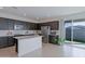 Open kitchen layout boasting dark wood cabinetry, a central island, and stainless steel appliances at 17487 W Daley Ln, Surprise, AZ 85387