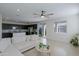 Open-concept living room and kitchen with a large sectional sofa, stainless steel appliances, and modern lighting at 17487 W Daley Ln, Surprise, AZ 85387