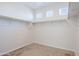 Walk-in closet featuring neutral carpeting, shelving, and natural light coming through three small windows at 17487 W Daley Ln, Surprise, AZ 85387