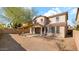 Desert landscaped backyard with a covered patio and views of the two-story home at 17655 W Tasha Dr, Surprise, AZ 85388