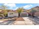 Single-story home with a two-car garage, desert landscaping, and a well-maintained lawn at 17655 W Tasha Dr, Surprise, AZ 85388