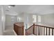 Upstairs hallway with wood railing overlooking the entryway of the home at 17655 W Tasha Dr, Surprise, AZ 85388