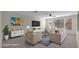 Bright living room showcasing neutral tones, a ceiling fan, and ample natural light at 17655 W Tasha Dr, Surprise, AZ 85388